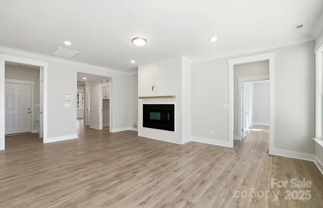 an empty room with wooden floor and fireplace