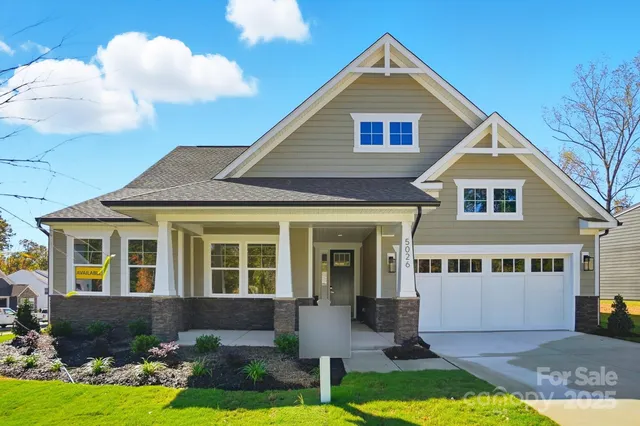 a front view of a house with yard and green space