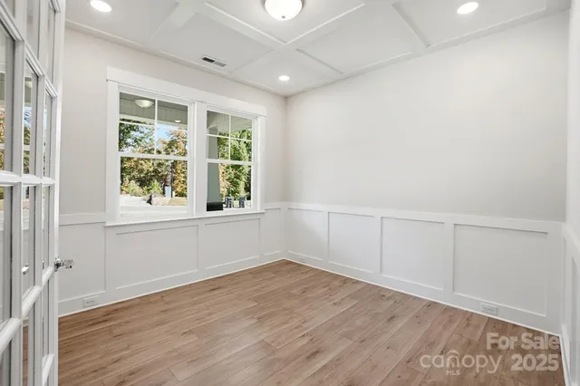 an empty room with wooden floor and white walls