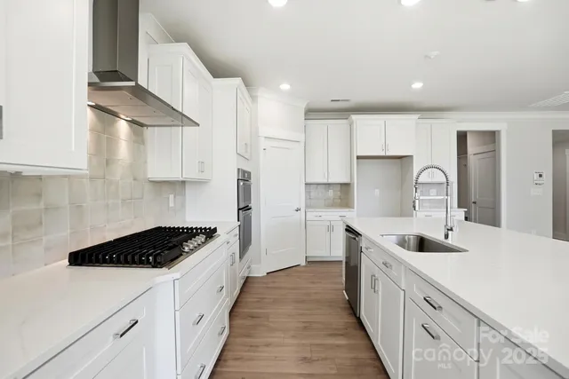 a kitchen with kitchen island a sink a stove and cabinets