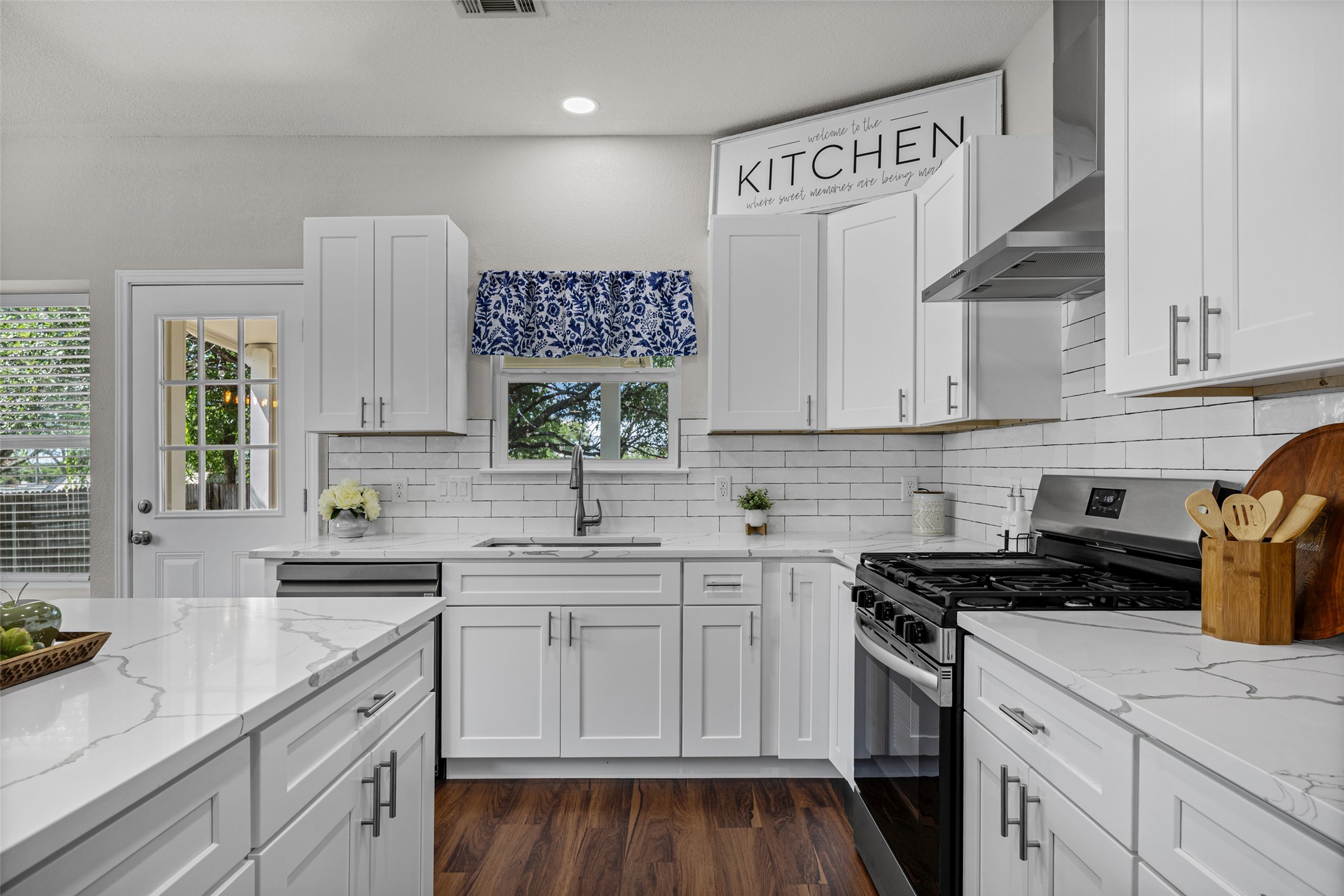 1524 Lochaline Loop Pflugerville, TX 78660 - Photo 10 of 22 A well-lit kitchen with sleek white cabinetry, gleaming countertops, and modern appliances offers a pristine culinary space.