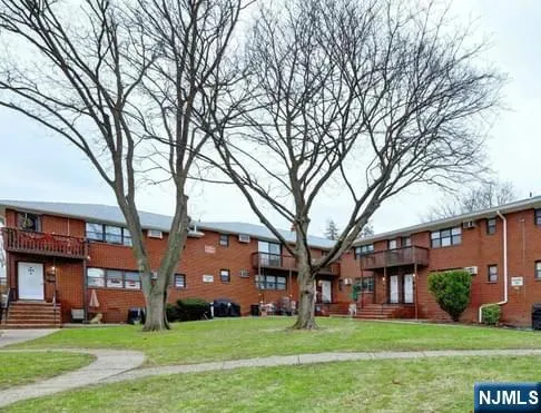 a brick house with trees in front of it