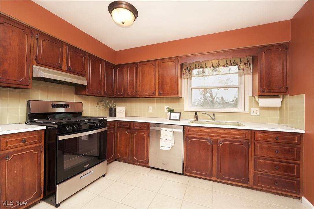 2674 Smith Road Fairlawn, OH 44333 - Photo 12 of 31 Kitchen with stainless steel appliances, light countertops, a sink, and under cabinet range hood