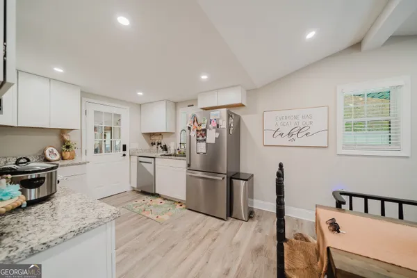 a kitchen with stainless steel appliances granite countertop a refrigerator sink and stove