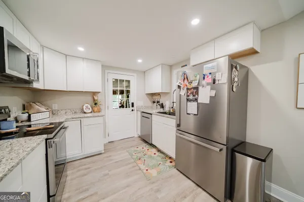 a kitchen with a refrigerator a sink and cabinets