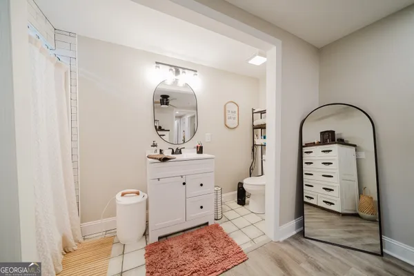 a spacious bathroom with a mirror a sink and a shower