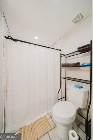 a white toilet sitting next to a shower curtain