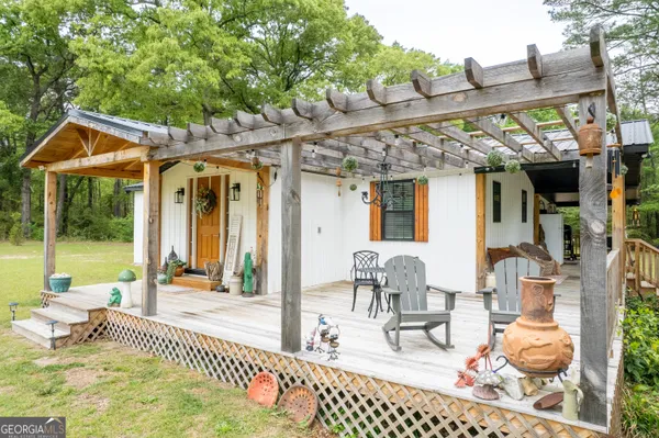 a patio with table and chairs and potted plants