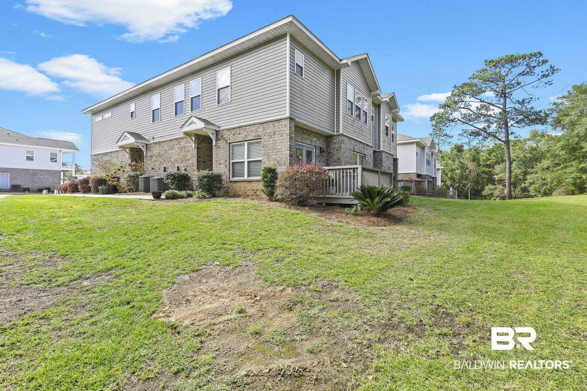 6867 Spaniel Drive, Unit B Daphne, AL 36527 - Photo 27 of 36 Exterior space featuring a yard, central AC unit, and a deck