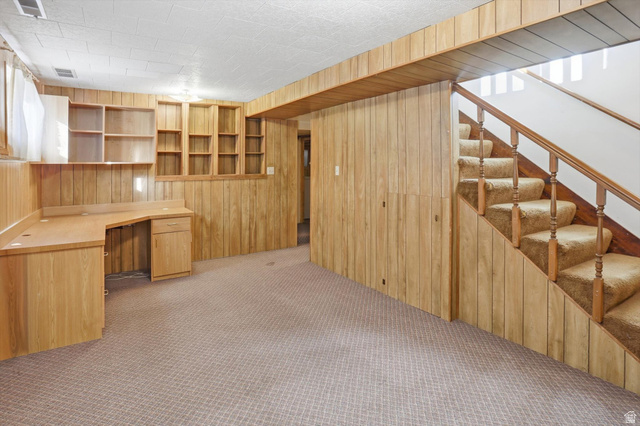 380 North 200 West Logan, UT 84321 - Photo 19 of 29 Family room featuring wood walls, built in desk, and light carpet