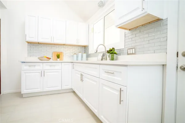 a kitchen with a sink cabinets and a window