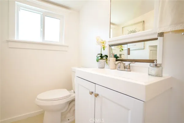a bathroom with a sink a toilet and mirror