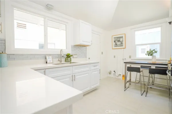 a kitchen with a sink a table and chairs in it