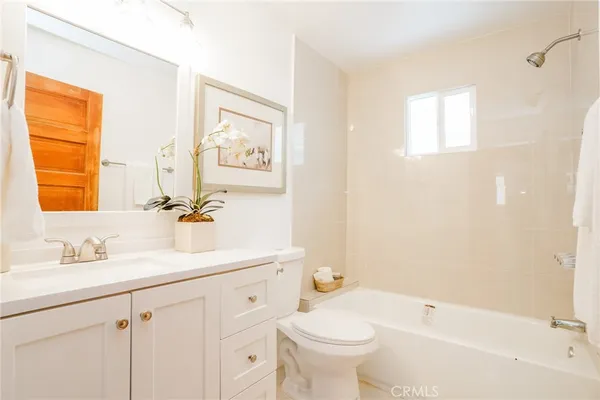 a bathroom with a sink mirror toilet and bathtub