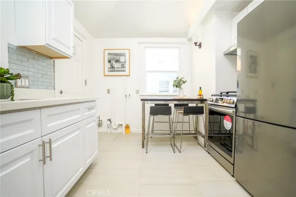 a view of a kitchen with a sink and chairs