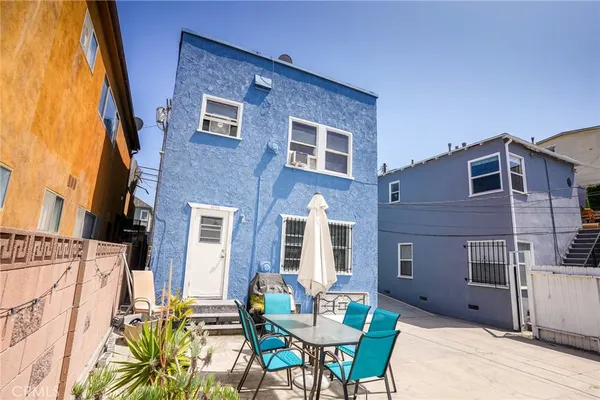 a backyard of a house with table and chairs