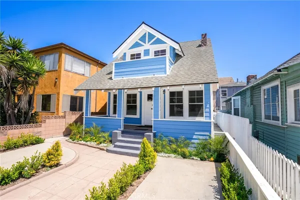 a front view of a house with a yard and potted plants