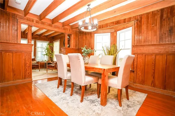 a dining room with furniture a chandelier and wooden floor