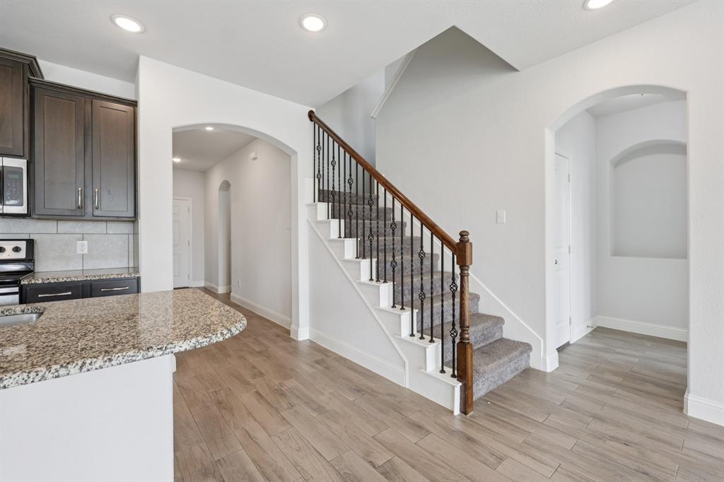 1205 Templin Avenue Forney, TX 75126 - Photo 11 of 40 a view of a hallway with wooden floor and staircase