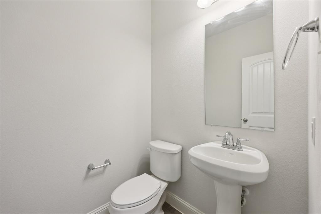 1205 Templin Avenue Forney, TX 75126 - Photo 14 of 40 a bathroom with a sink a toilet and mirror