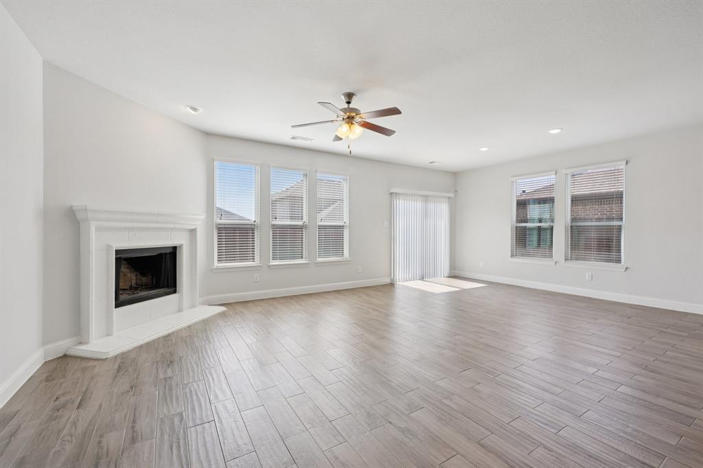 1205 Templin Avenue Forney, TX 75126 - Photo 3 of 40 a view of an empty room with wooden floor fireplace and a window