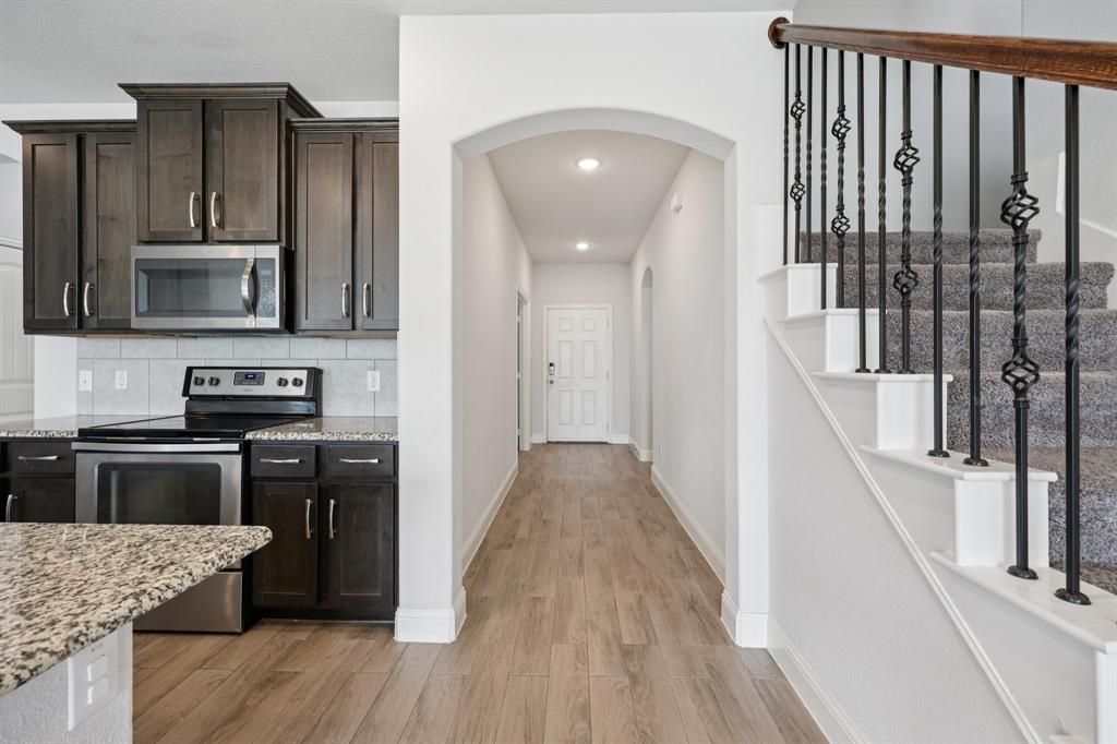 1205 Templin Avenue Forney, TX 75126 - Photo 9 of 40 a kitchen with granite countertop a stove top oven and sink
