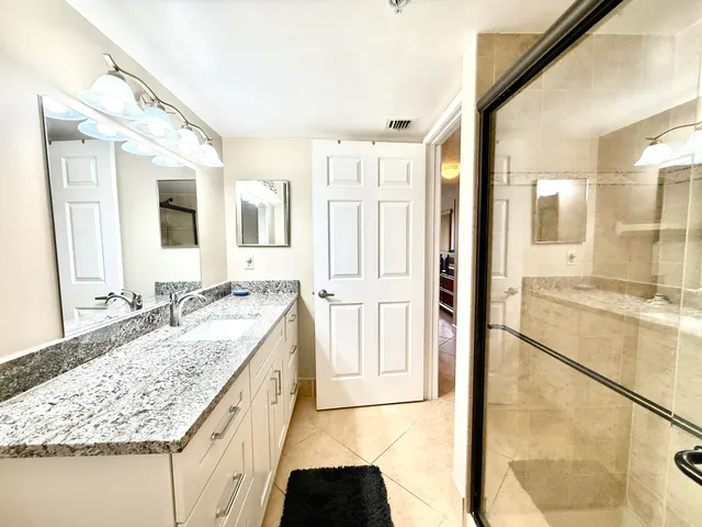 a bathroom with a granite countertop sink and a mirror