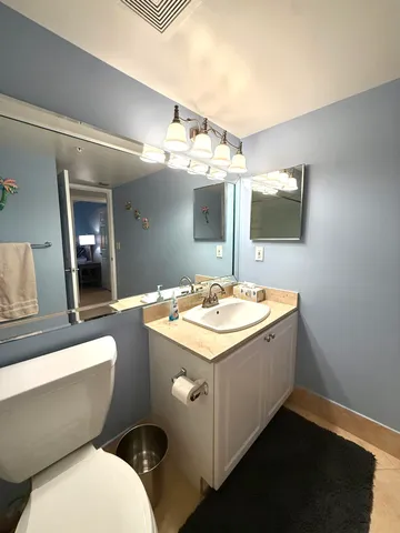 a bathroom with a toilet a sink and mirror