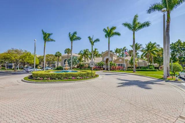 a view of a swimming pool with a yard and palm trees