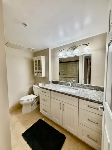 a bathroom with a granite countertop sink and a mirror