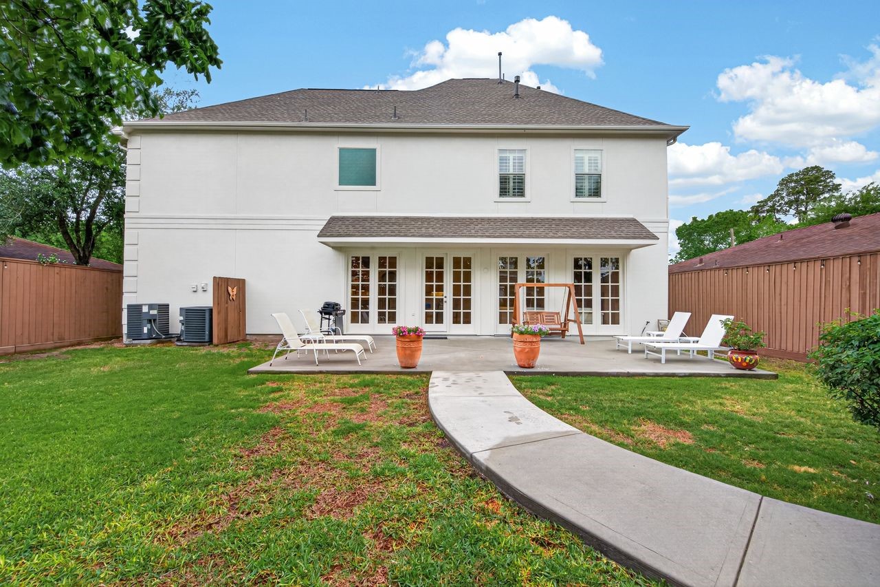 10932 Lasso Lane Houston, TX 77079 - Photo 34 of 38 a front view of a house with a yard table and chairs