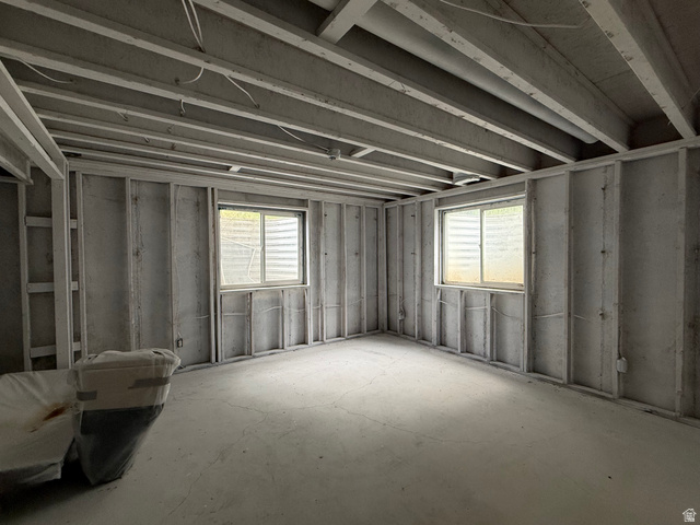 838 East Mountain Road Logan, UT 84321 - Photo 31 of 37 Unfinished basement space featuring exposed ceiling joists, concrete flooring, and two window wells
