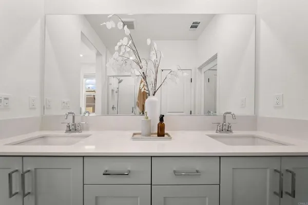 a bathroom with double sink and a mirror