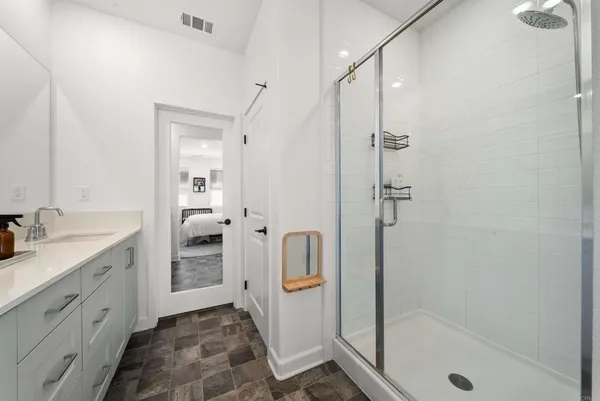 a bathroom with a shower sink and mirror