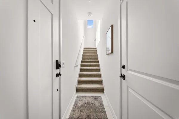a view of hallway with stairs and wooden floor