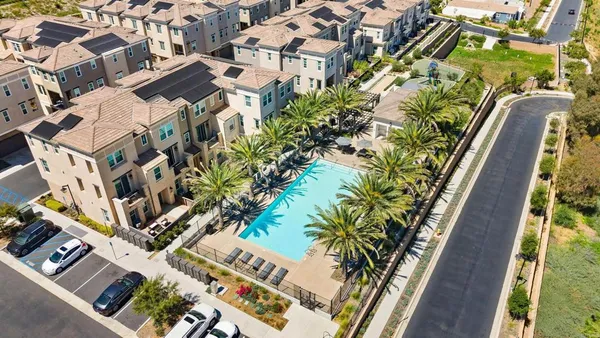 an aerial view of a multi story residential apartment building with yard