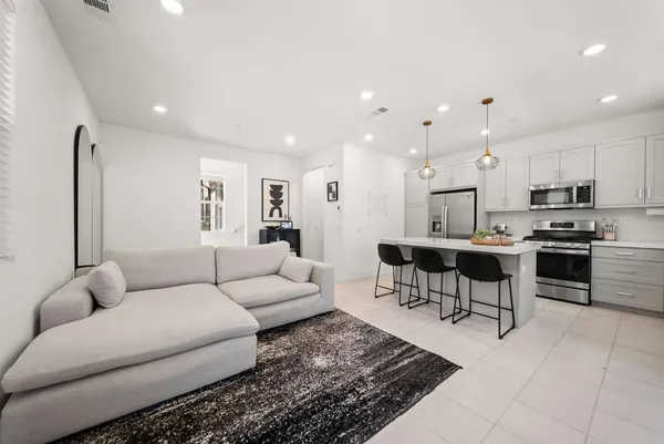 a living room with furniture and kitchen view
