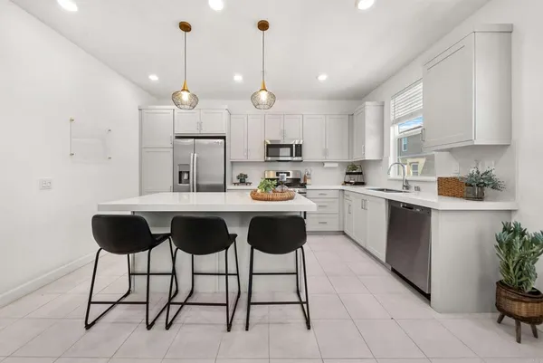 a kitchen with kitchen island granite countertop a sink a center island and cabinets