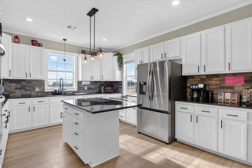 278 Leuschner Road Elm Mott, TX 76640 - Photo 16 of 31 a kitchen with granite countertop a refrigerator a sink and white cabinets