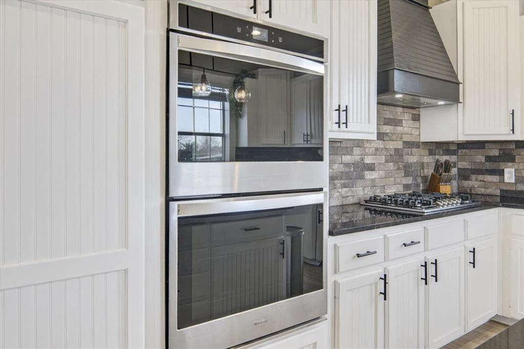 278 Leuschner Road Elm Mott, TX 76640 - Photo 18 of 31 a kitchen with granite countertop white cabinets and white appliances