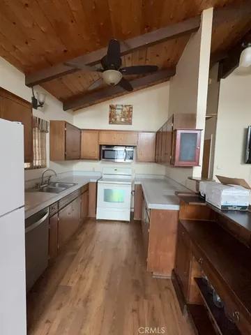 a large kitchen with stainless steel appliances wooden floors and wooden cabinets