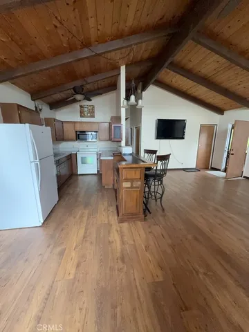a living room with a table chairs and a wooden floor