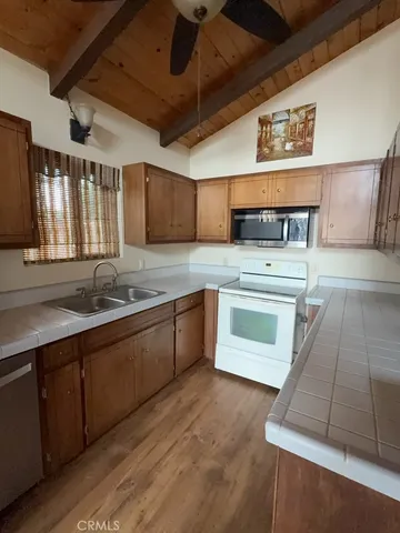 a kitchen with stainless steel appliances granite countertop a sink a stove and a wooden floors