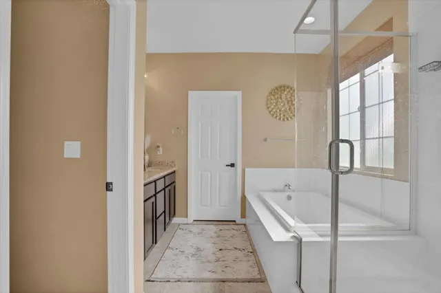 a bathroom with a tub sink and mirror