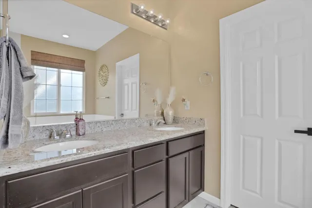 a bathroom with a granite countertop sink and a mirror