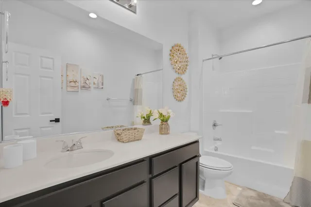 a bathroom with a granite countertop sink a toilet and shower