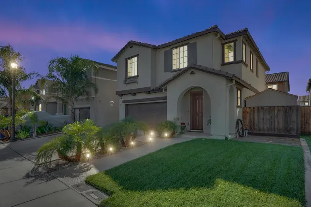 a front view of a house with a garden and yard
