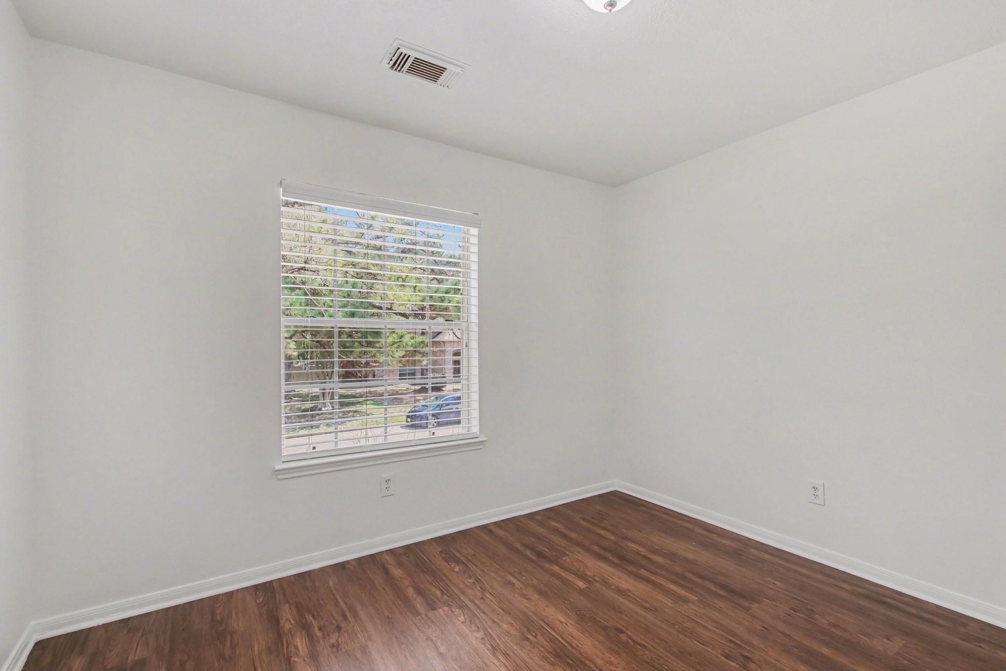 7203 Glen Rosa Drive Katy, TX 77494 - Photo 16 of 28 an empty room with wooden floor and windows