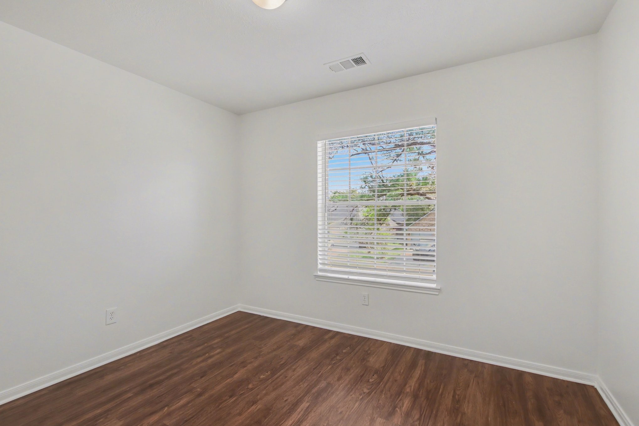 7203 Glen Rosa Drive Katy, TX 77494 - Photo 18 of 28 an empty room with wooden floor and windows