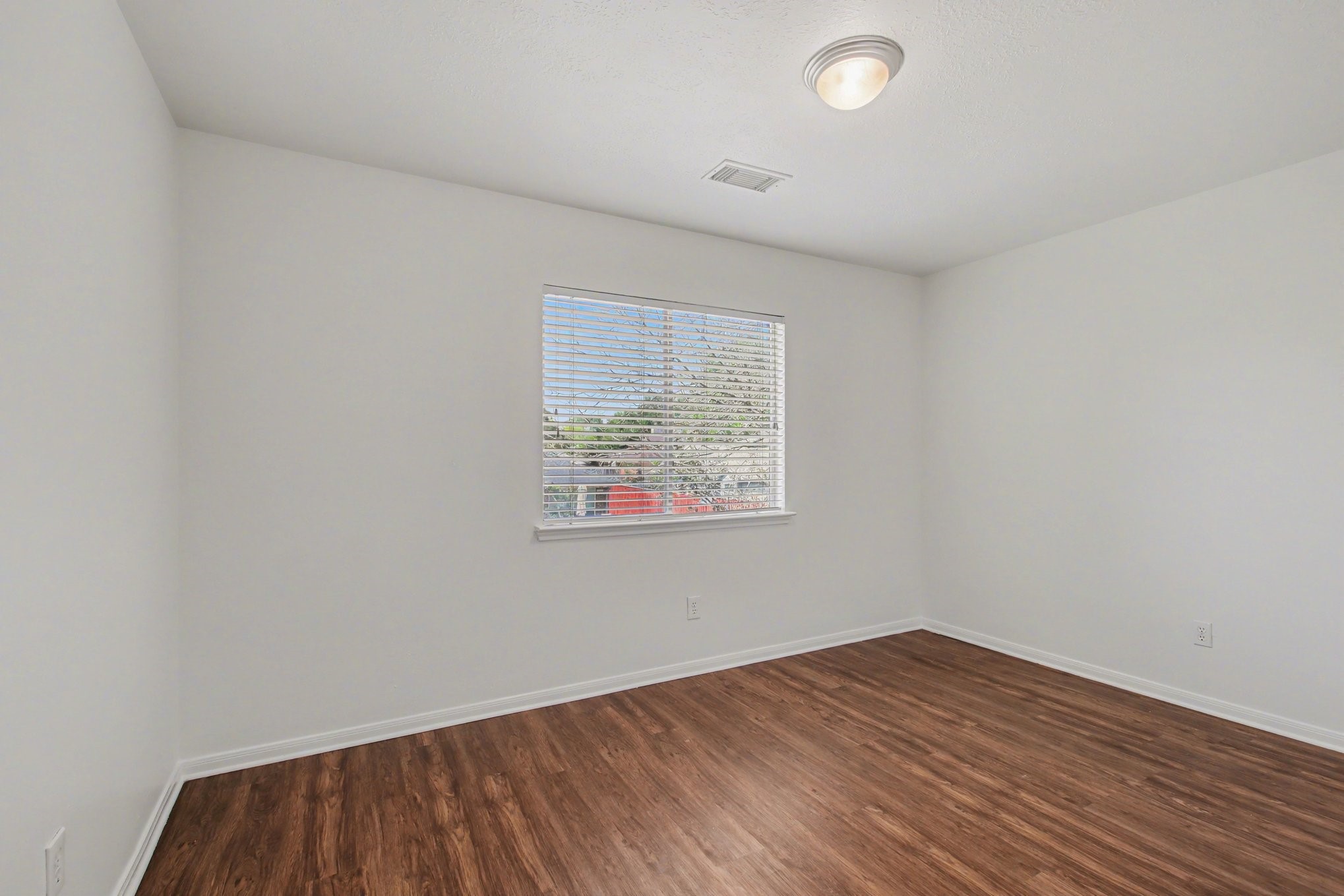 7203 Glen Rosa Drive Katy, TX 77494 - Photo 21 of 28 an empty room with wooden floor and windows